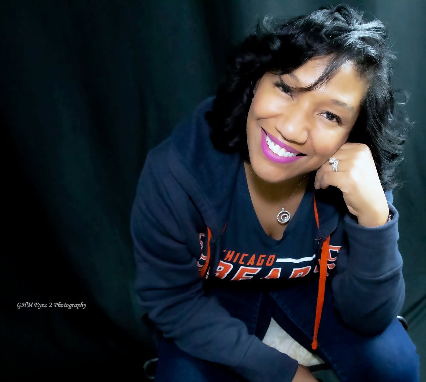 Warm personal portrait of a smiling woman against a dark backdrop