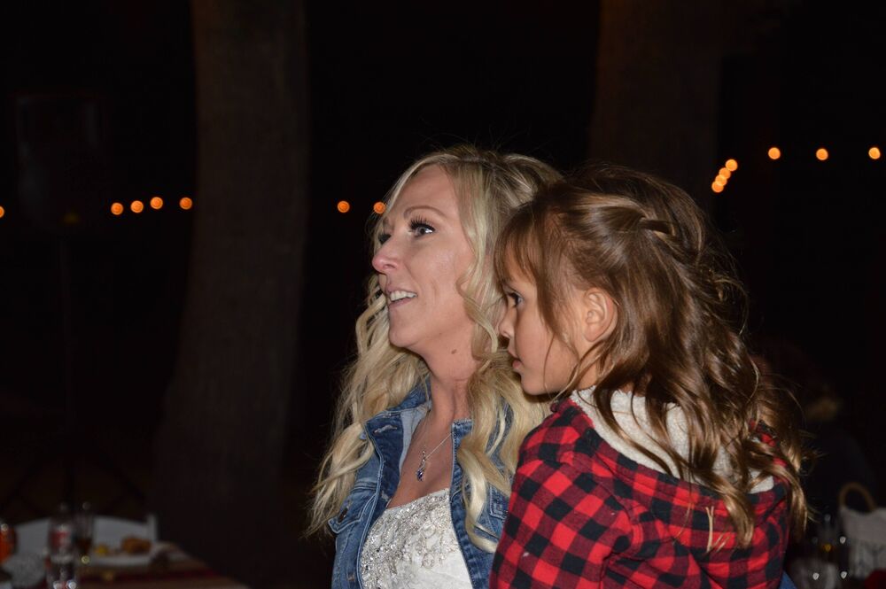 A smiling bride sharing an evening celebration with a young girl