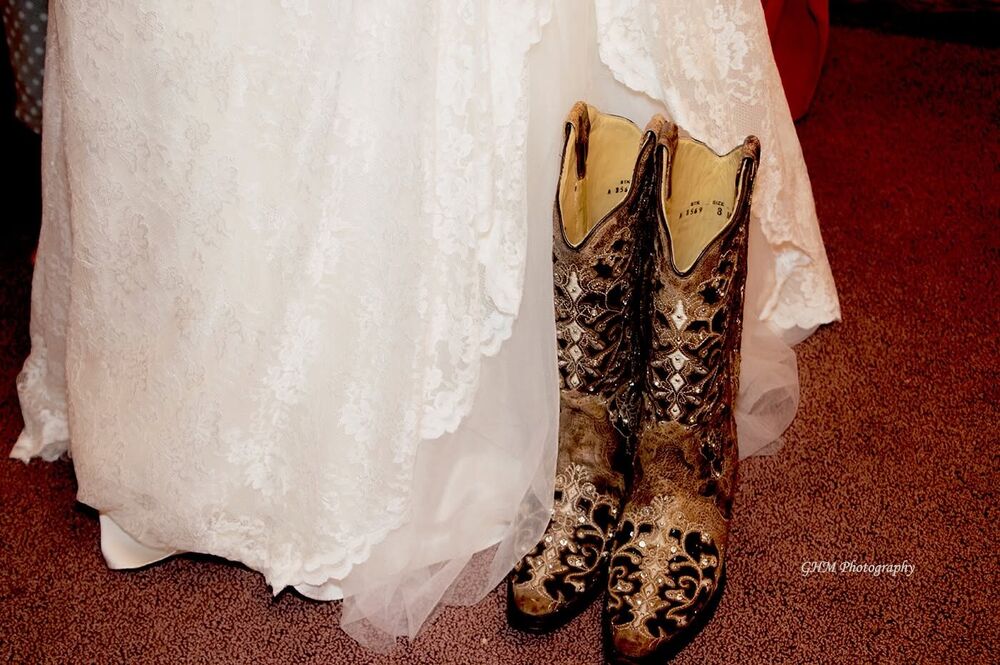 Decorative cowboy boots beneath a wedding dress