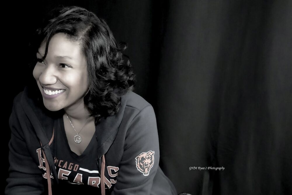 Relaxed portrait of a smiling woman against a dark background