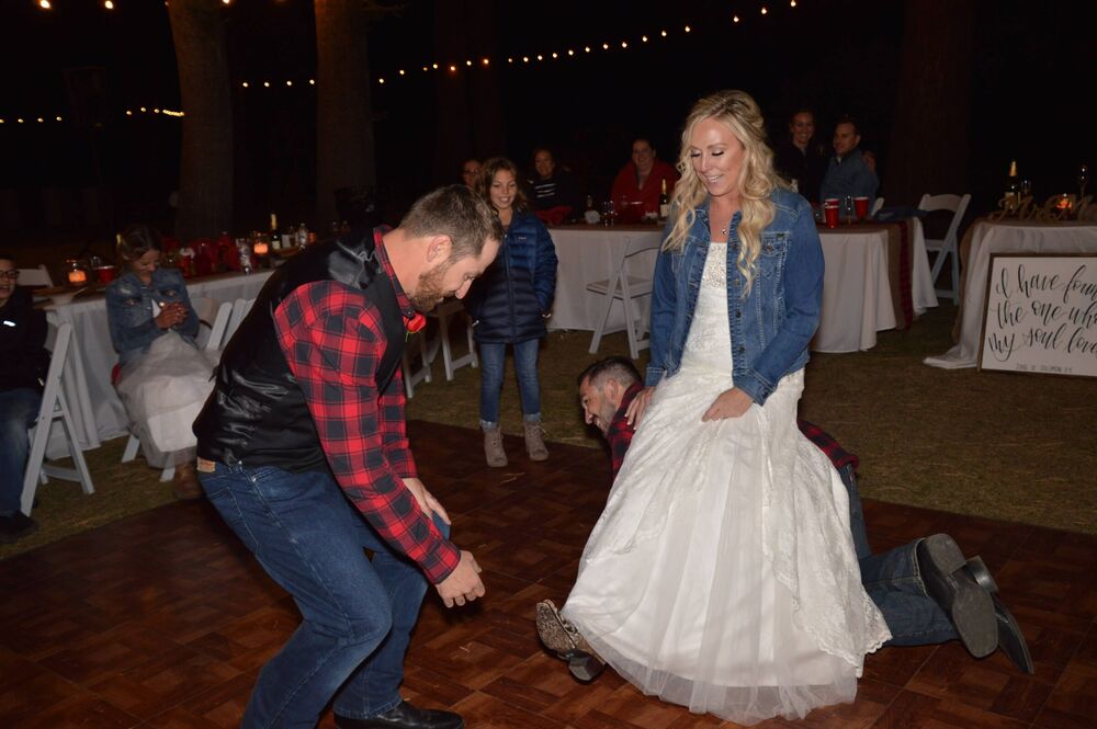 A bride and guest dancing at an outdoor wedding celebration