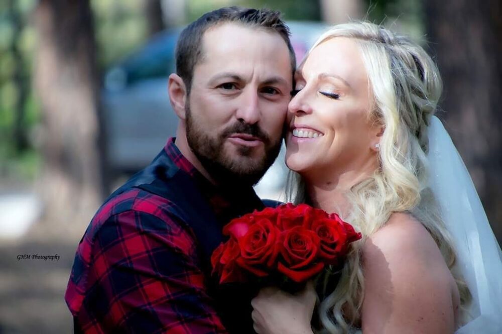 A newly married couple sharing a close moment with red roses