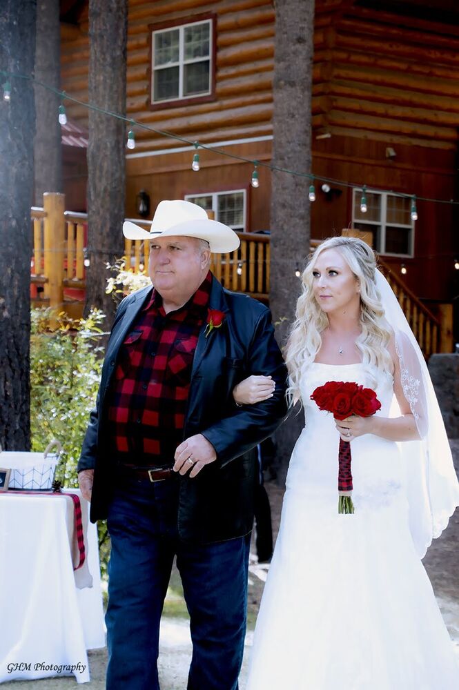 A bride being escorted toward an outdoor wedding ceremony
