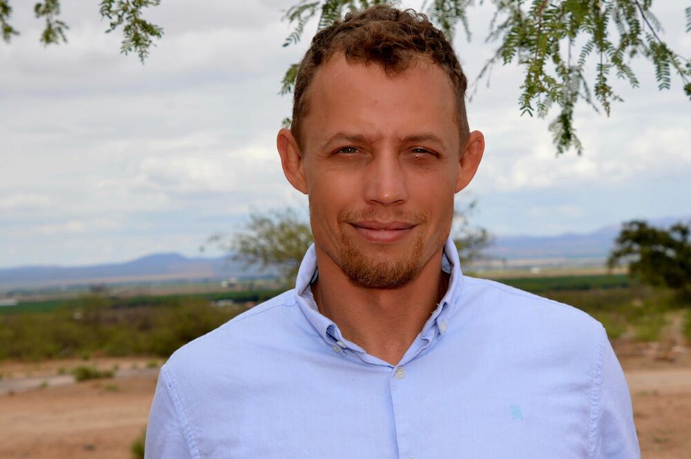 Outdoor professional headshot of a man with a distant landscape behind him