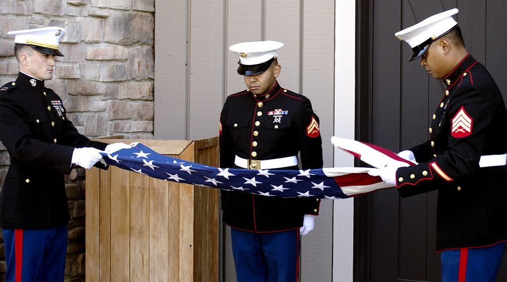 United States Marines carefully folding an American flag