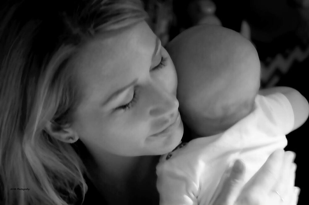 A mother embracing her baby in black and white