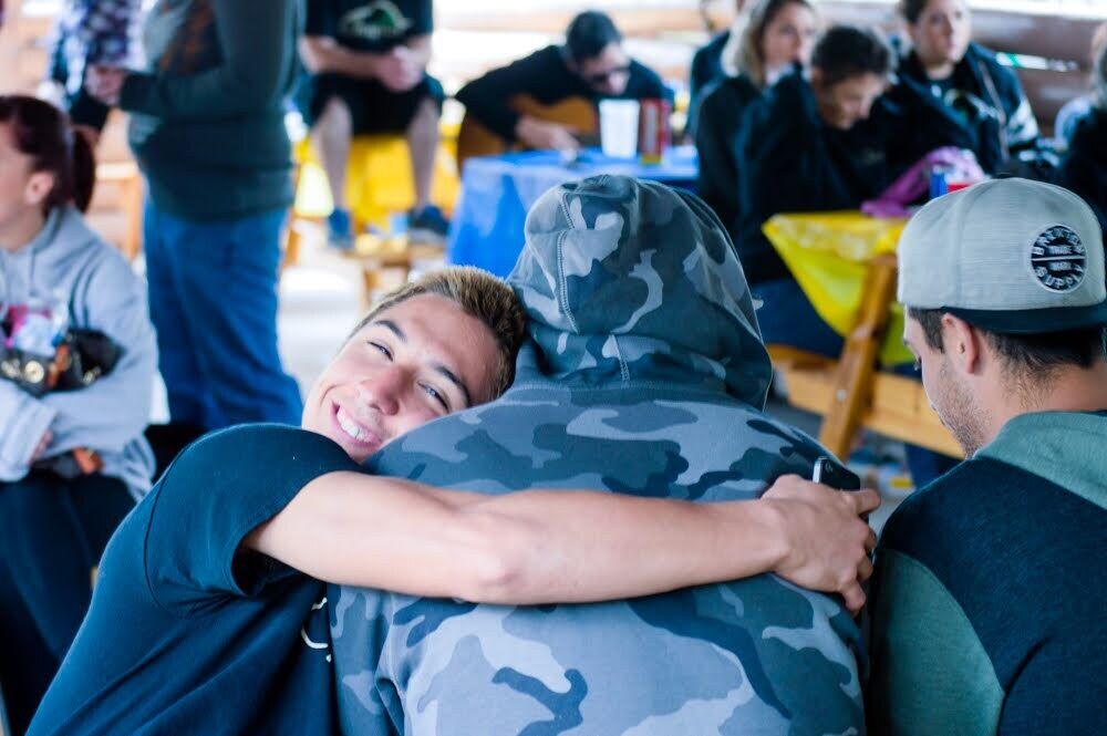 Friends sharing an emotional embrace at a casual gathering