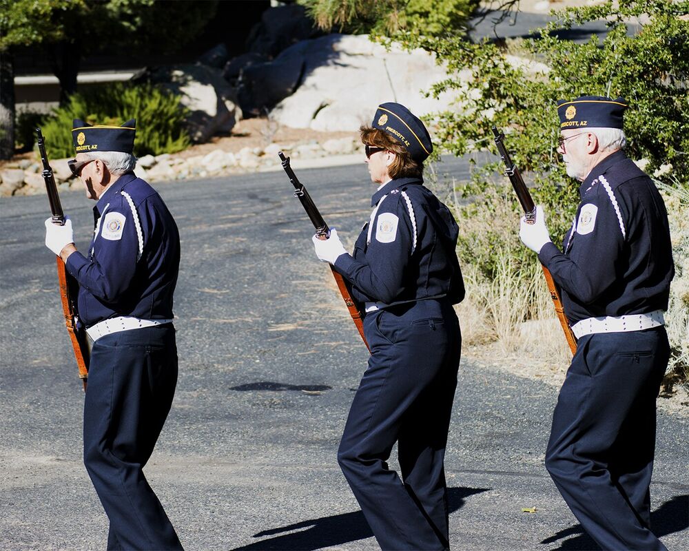 A uniformed honor guard carrying ceremonial rifles