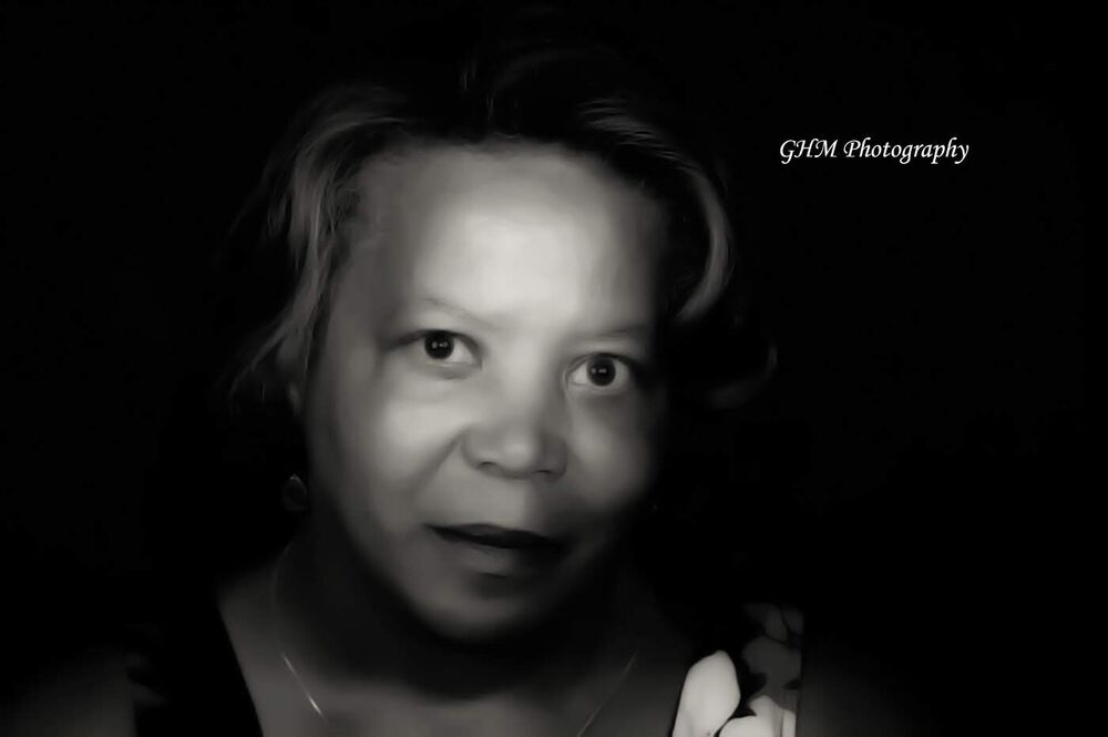 Black-and-white portrait of a young girl against a dark background